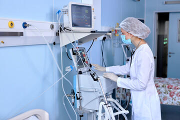 Confident Caucasian Female Doctor Setting Up Medical Equipment Device For Treating Patient, Checking Health Condition Of Sick Person. In Modern hospital Ward Room, Alone