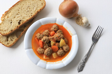 Sour Meatballs with Potatoes and Carrots in a White Plate