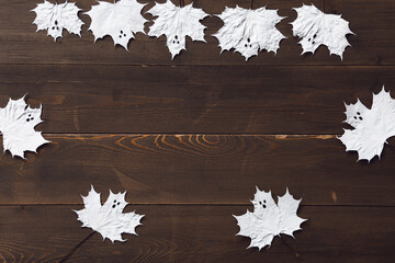 Paper ghosts looks like marle leaf on a dark wood. Flatlay. Copy space.