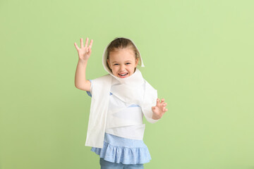 Funny little girl wrapped in toilet paper on color background