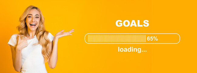 Overjoyed blonde lady pointing at GOALS loading process bar, full of hopes and expectations on orange background