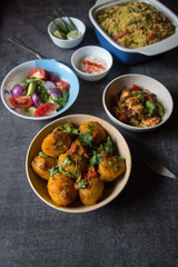 Indian lunch menu dum aloo or potato masala, pulao or vegetable fried rice and paneer or cottage cheese served with salad and condiments. Top view.