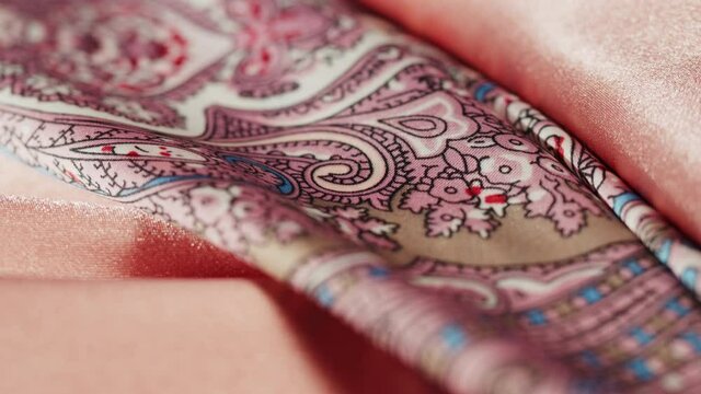 Pink silk fabric close-up, arabian design or indian pattern. Cloth texture background. Macro shooting of textile.