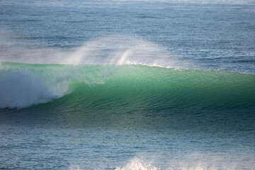 Young surfer riding perfect surf wave at the beach of Caños de Meca
