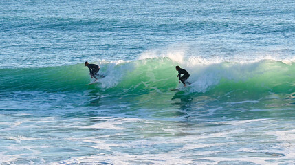 Two surfers sharing a nice wave on the Atlantic coast of south Spain in Cadiz