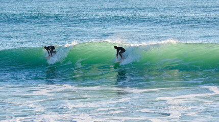 Two surfers sharing a nice wave on the Atlantic coast of south Spain in Cadiz
