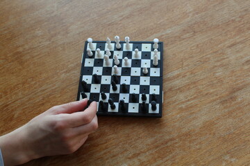 hand holding chess piece on chess board