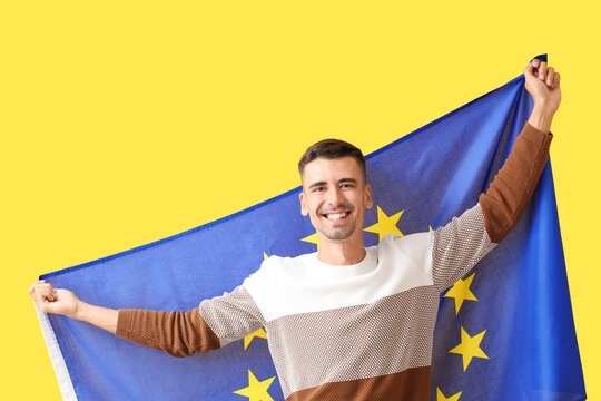 Young man with flag of European Union on color background
