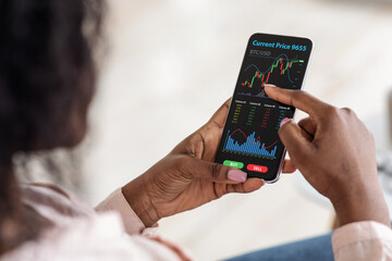 African american woman checking bitcoin price, using mobile app