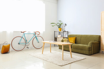 Interior of modern flat with sofa, table and bicycle