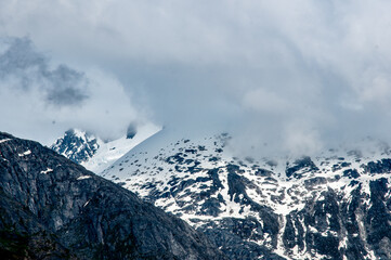 snow covered mountain peaks with fogg