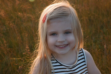 Headshot of happy toddler girl, outdoor portrait with natural light.