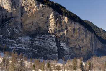 Famous Staubbach Fall at mountain village Lauterbrunnen at Bernese Highlands at the Swiss Alps on a sunny winter day. Photo taken January 15th, 2022, Lauterbrunnen, Switzerland.