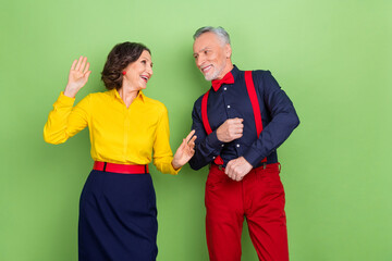 Photo of two overjoyed positive people enjoy dancing free time holiday isolated on green color background