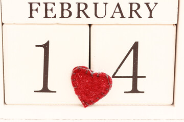 Valentine’s Day. February 14th , date calendar on white background and a red heart.  White block calendar present date 14 and month February.