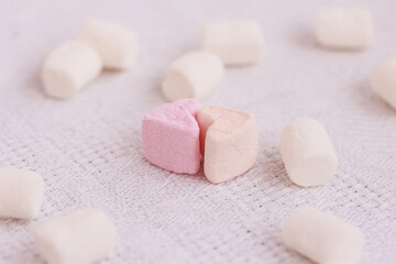 Two Marshmallow hearts together and white  Marshmallows on white  background. Love, romance concept.