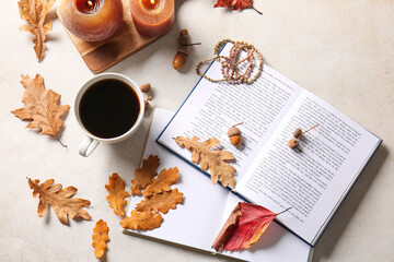 Books, cup of coffee, accessories and autumn decor on light background