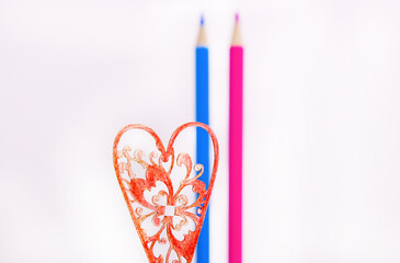 colored pencils on a white background. a couple in love. blue and pink pencils. colored pencils and a red heart