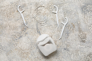 Dental floss with toothpicks on grunge background