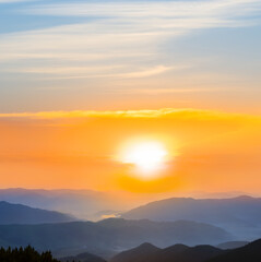 mountain chain silhouette in blue mist at the sunset