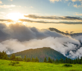green mountain in dense clouds at the sunset