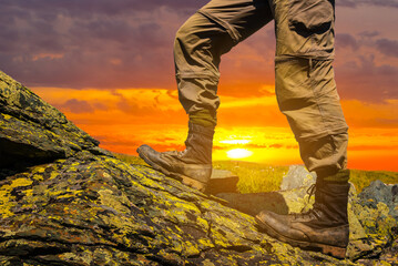 closeup hiker mount slope ascending on dramatic sunset background, travel scene