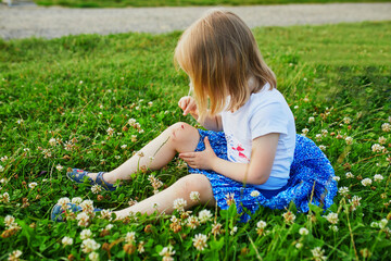 Fototapeta premium Cute little girl sitting on the ground after falling down