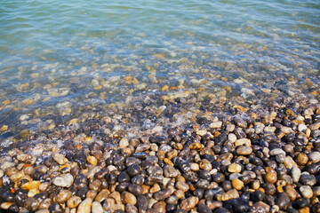 Clear water and and pebbles on a beach at Atlantic coast at Normandy, France
