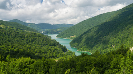 Lake among wooded hills. Nature image in the spring season .