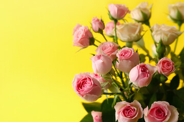 Bouquet of beautiful roses on yellow background