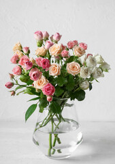 Vase with bouquet of beautiful roses on table