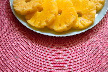 Sweet pineapple rings on a turquoise plate with empty space for your text