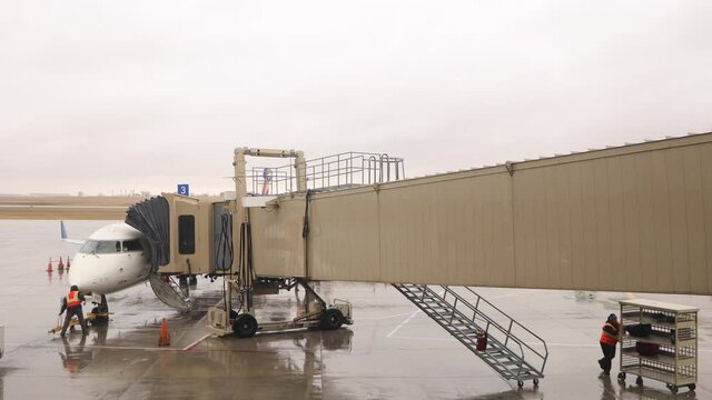 Getting the plane ready for the next flight. Safety checks being done and luggage being loaded up for the passengers. Rainy cold day. 