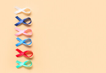 Different awareness ribbons on beige background. World Cancer Day