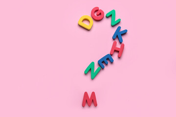 Question mark made of colorful letters on pink background