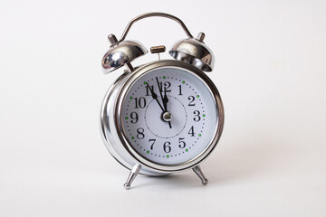 Metallic alarm clock with shadow on gray background