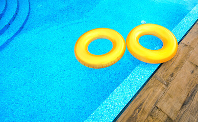 Two floating rings at the swimming pool with a blue water.