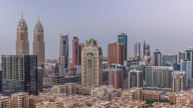 Skyscrapers in Barsha Heights district and low rise buildings in Greens district aerial day to night timelapse.