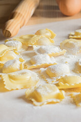 Fresh ravioli pasta durind cooking on light background. Vertical image
