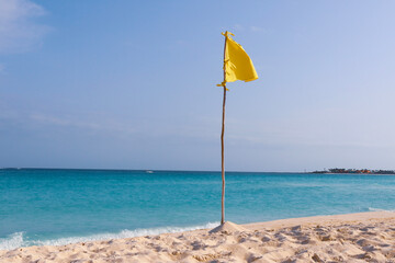 Yellow flag during a beautiful day at the beach in Cancun. 
