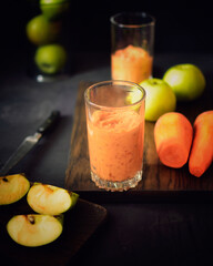 smoothie apple and carrot on a black background with ingredients