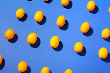 Tasty kumquat fruits on blue background