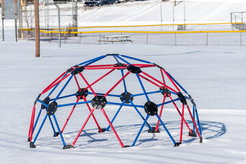 Dome monkey bars in a playground after heavy snow go unused. © Chet Wiker