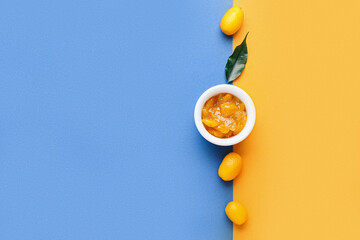 Bowl of tasty kumquat jam and fresh fruits on color background