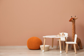 Cute child room interior with furniture and toys near pink wall. Space for text