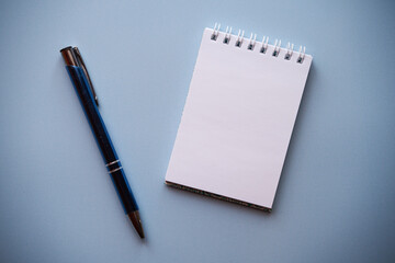 notatnik i długopis na niebieskim tle - obrazy, fototapety, plakaty