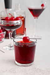 Glass of tasty Manhattan cocktail on light background