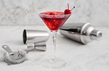 Glass of iced Manhattan cocktail on light background