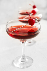 Glass of tasty Manhattan cocktail on light background, closeup