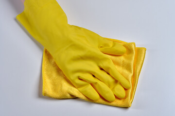 The worker removes dust from the furniture. Cleaning service . A hand in a yellow glove with a dust rag close-up.